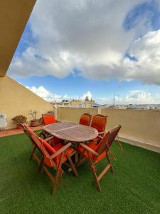 a table and chairs on a balcony with a view at Bright Modern Apartment with Rooftop in Mqabba