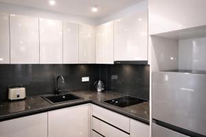 a kitchen with white cabinets and a sink at Verinn Apart Hotel in Dilijan
