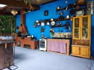 a kitchen with a blue wall with pots and pans at Chalé no Plantar em Casa in São Roque