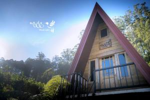 a house with a large door and a balcony at Kedella wood cabin in Nuwara Eliya
