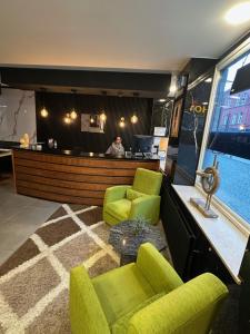 a lobby with two green chairs and a bar at Hotel Albert in Brussels