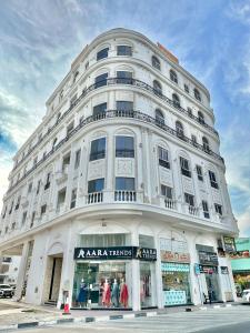 a large white building on the corner of a street at Entire Studio Apartment with King Bed in Ajman 