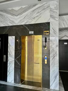 a elevator with a gold door in a building at Entire Studio Apartment with King Bed in Ajman 