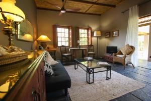 a living room with a couch and a table at Abigail's Garden Cottage in Montagu