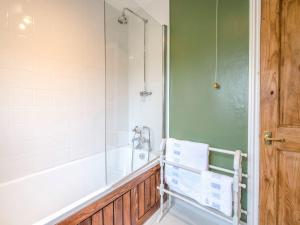 a bathroom with a shower and a tub and a sink at Beacon Cottage in Ilkley