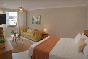 a hotel room with a bed and a couch at Copacabana Stay in Serra