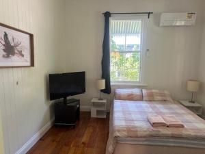 a bedroom with a bed and a flat screen tv at Gabba Beautiful rooms in Brisbane