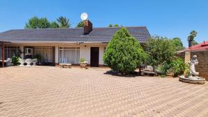 a house with a brick driveway in front of it at Highway Haven in Stilfontein
