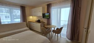 a living room with a couch and a table with chairs at Apartamentai šalia baseino in Palanga