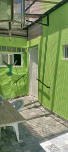 a green building with a green wall and a table at Hospedaje en San Isidro in San Isidro