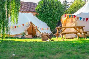 a tent and a picnic table in the grass at Aldwark Bridge Glamping - Aurora Tent in Aldwark +32 photos