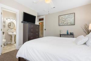 a bedroom with a white bed and a television at Dreams2Reality | Historic Branson Hotel - Serendipity Room - Downtown in Branson