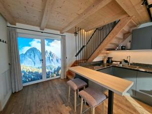 a kitchen with a large window with a mountain view at Praterhof Chalet in Südtirol - Natur, Ruhe & Bergblick in Bressanone