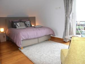 a bedroom with a bed with purple blankets and pillows at stunning Family Gîte Retreat in Stoumont