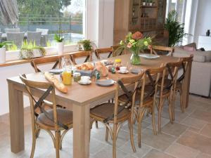 a wooden dining room table with chairs and food on it at stunning Family Gîte Retreat in Stoumont +32 photos