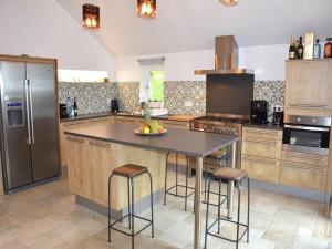 a kitchen with a large island with bar stools at stunning Family Gîte Retreat in Stoumont