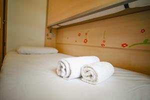 two rolls of towels sitting on top of a bed at A un paso de Grandvalira I Refugio Amplio y Sereno I Solanelles in Soldeu