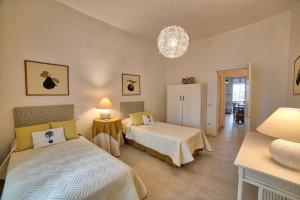 a bedroom with two beds and a chandelier at Lemon Home in Olbia