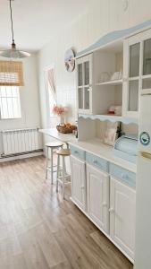a kitchen with white cabinets and a table and chairs at A beira do Mar in Bueu