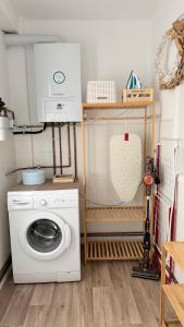 a laundry room with a washing machine and a washer at A beira do Mar in Bueu