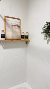 a bathroom with a picture and three candles on a shelf at A beira do Mar in Bueu +42 photos