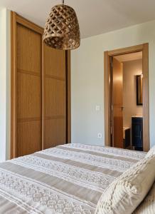 a bedroom with a white bed with a chandelier at El Mirador del Susarón in Puebla de Lillo +20 photos