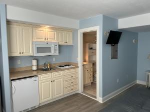 a kitchen with white cabinets and a white microwave at Sunbeach Condo 900 Wesley Avenue Unit 109 in Ocean City