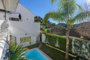 a villa with a swimming pool and a palm tree at Villa Atajate Secret by SuperHosts in Atajate