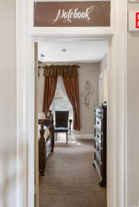 a door into a bedroom with a desk and a chair at Dreams2Reality | Historic Branson Hotel - Notebook Room - Downtown in Branson +14 photos