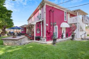 a pink house with a patio in the yard at Dreams2Reality | Historic Branson Hotel - Notebook Room - Downtown in Branson