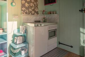 a small kitchen with a sink and a microwave at The Hideaway at Duffryn Mawr Self Catering Cottages in Cowbridge +49 photos