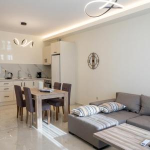 a living room with a couch and a table with chairs at Ionian Port Suite in Ágios Rókkos