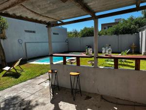 a patio with a table and stools next to a pool at La Luján Ayres de Campo in Luján