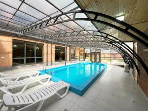 a large swimming pool with lounge chairs in a building at Home Comfort in Kotaykʼ