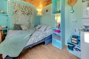 a bedroom with a bed in a room with blue walls at The Hideaway at Duffryn Mawr Self Catering Cottages in Cowbridge