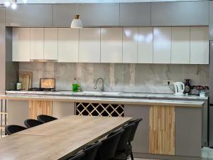 a kitchen with a wooden table and a counter top at Home Comfort in Kotaykʼ
