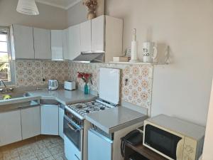 a kitchen with a stove top oven next to a microwave at Lahogareña in La Cieneguita +13 photos