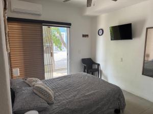a bedroom with a bed and a sliding glass door at Habitat in Barra de Navidad