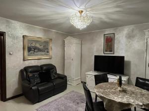 a living room with a chair and a table and a television at Casa Adi Sucevița in Voivodeasa