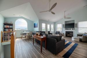 a living room with a couch and a table at King BEEch - Southern Shores, 300 Yds to Beach, Ocean View, Pool, Hot Hub, Fenced Yard in Southern Shores