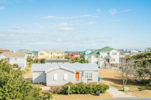 a house in a suburb with houses in the background at King BEEch - Southern Shores, 300 Yds to Beach, Ocean View, Pool, Hot Hub, Fenced Yard in Southern Shores