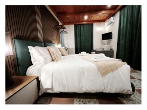 a bedroom with a large white bed with green curtains at Villa Nunziante Grand Estate, Pompei in Scafati
