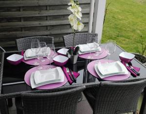 a table with pink and white plates and glasses on it at Wohnung an der Lagune in Büsum +18 photos