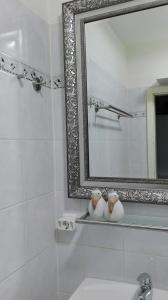 a white bathroom with a mirror and a sink at Wohnung an der Lagune in Büsum
