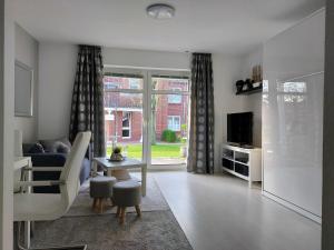 a living room with a couch and a tv at Wohnung an der Lagune in Büsum