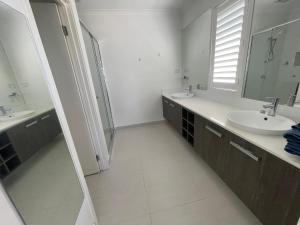 a white bathroom with two sinks and a mirror at Master's bedroom in Mount Duneed in Mount Duneed