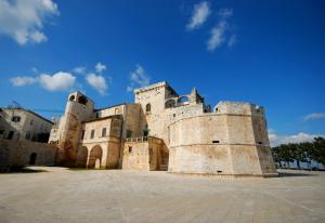 a large stone building with a blue sky in the background at Suite 20 in Conversano