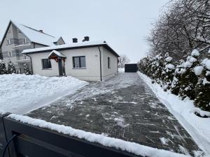 a snow covered driveway leading to a house at Klimatyczny Dom in Zamość