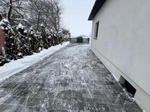 a snow covered sidewalk next to a building at Klimatyczny Dom in Zamość