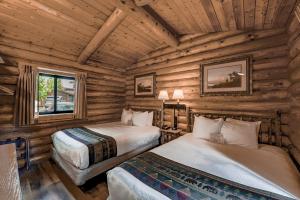 a bedroom with two beds in a log cabin at Cowboy Village Resort in Jackson +56 photos